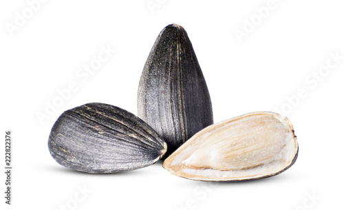 Two sunflower seed with one cracked in the foreground closeup isolated on white background