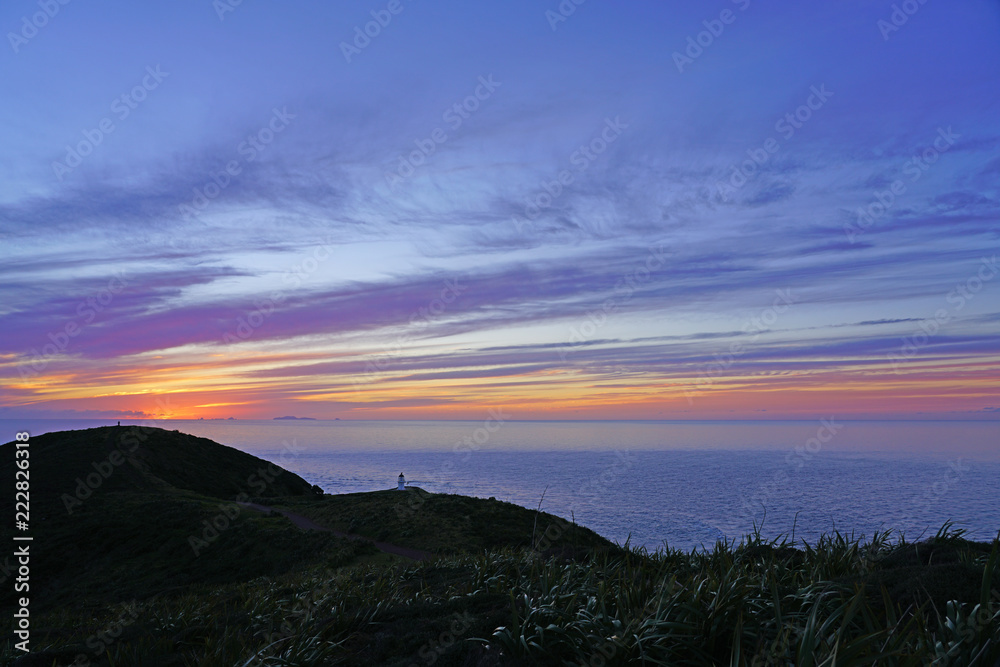 Sunset over Cape Reinga (Te Rerenga Wairua), the northwesternmost tip of the Aupouri Peninsula, at the northern end of the North Island of New Zealand, where the Tasman Sea meets the Pacific Ocean