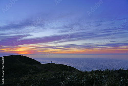 Sunset over Cape Reinga (Te Rerenga Wairua), the northwesternmost tip of the Aupouri Peninsula, at the northern end of the North Island of New Zealand, where the Tasman Sea meets the Pacific Ocean