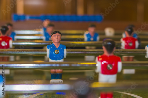 Blue and white uniform table soccer player figurine on foosball board
