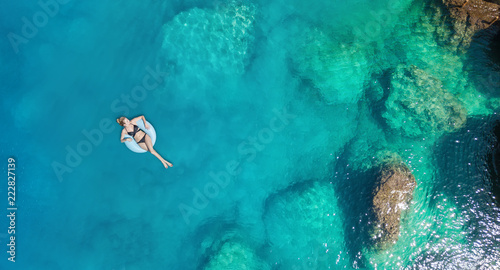 Aerial view at the girl on sea. Turquoise water from air as a background from air. Natural seascape at the summer time. Seascape from drone