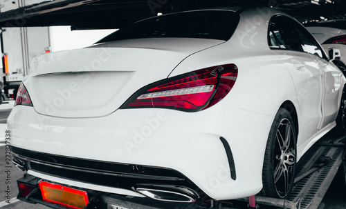 Closeup modern luxury white Back lights headlight and head lamp of powerful beast sport car . Dealership office showroom for sale background hype epic toned wallpaper. Tuning design Automobile rental 