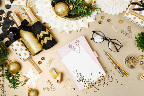 Mockup card and notebook on desk with Christmas decoration background in golden and black colors. Flat lay, top view