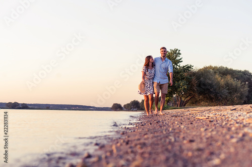 Couple walking on the beach at sunset