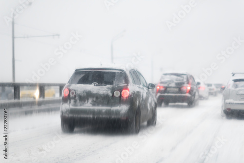 Car with lights on a snow covered road. © Mak