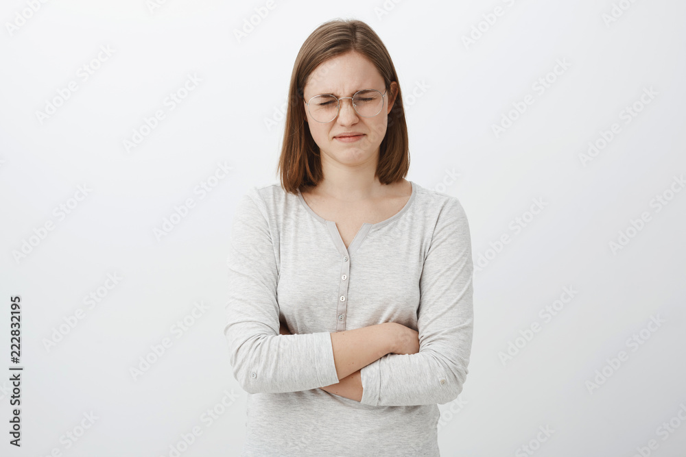 Waist-up shot of gloomy whining girl with short haircut complaining closing eyes and pursing lips crossing hands on chest feeling upset, envy or jealous losing in competition over gray background Waist-up shot of gloomy whining girl with short haircut complaining closing eyes and pursing lips crossing hands on chest feeling upset, envy or jealous losing in competition over gray background