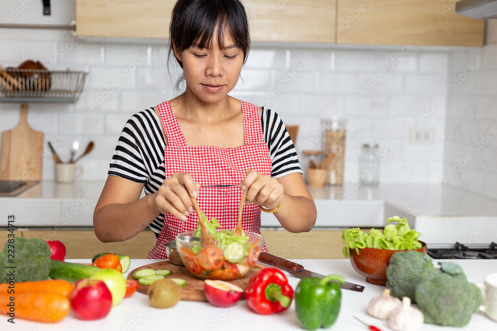 Healthy food Asian woman is cooking salad in kitchen, female preparing the vegetables and fruit at her house Healthy food Asian woman is cooking salad in kitchen, female preparing the vegetables and fruit at her house