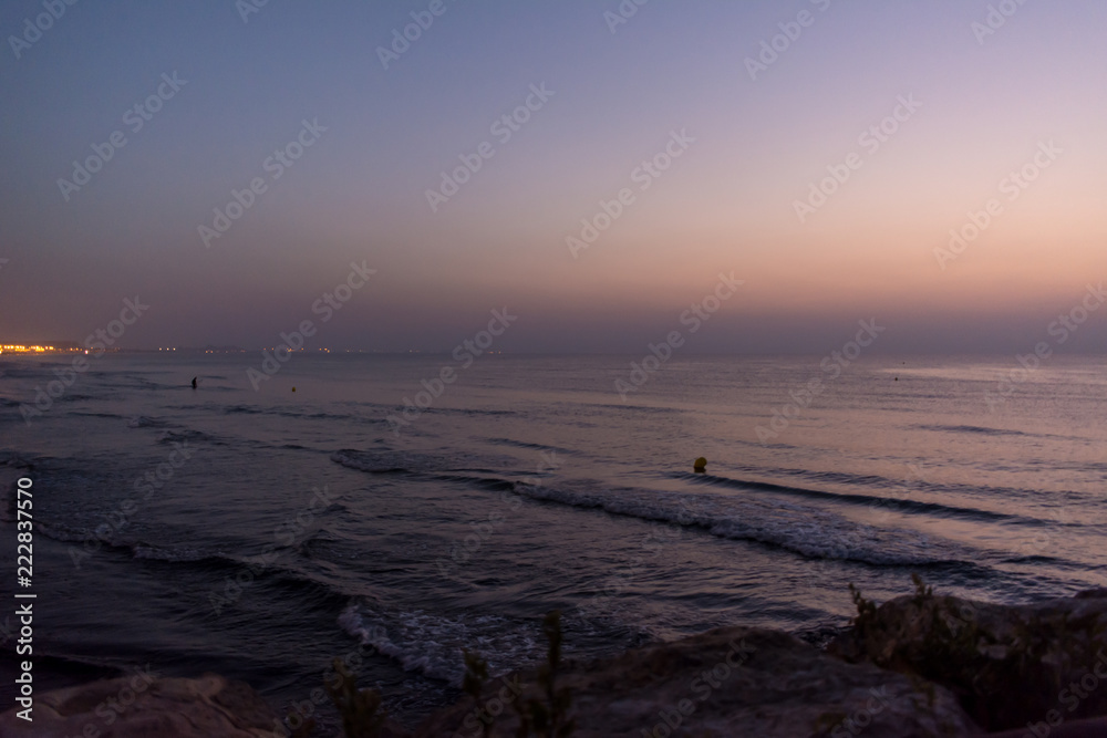 Sea waves with buoys and horizon in early morning at dawn