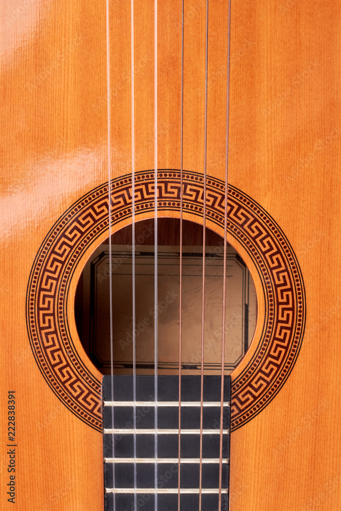 Ukulele guitar close up. Detail of yellow acoustic guitar, vertical image. Vintage musical guitar background.