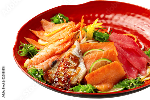 Isolated plate of sashimi including tuna, shrims, salmon served with soy sauce isolated at white background.