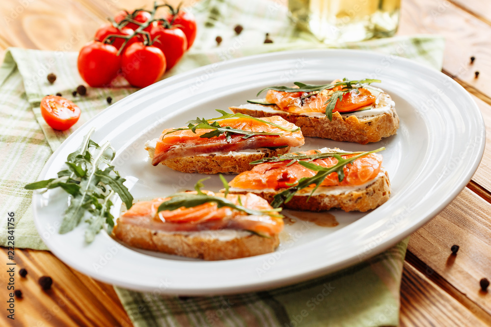 Whole grain bread with avocado paste and salmon decorated with arugula. Top view