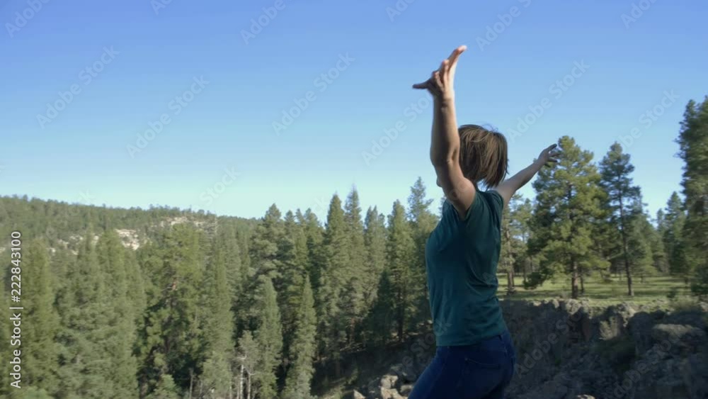 A young woman raising her arms in adoration for nature and creation A young woman raising her arms in adoration for nature and creation