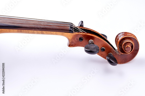 Fototapeta Scroll of the violin on white background. Head of vintage violin over white background. Construction of cello: scroll and peg box. Flat lay image.