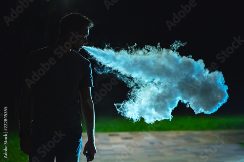 The man smoking on the street. evening night time photo