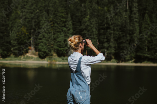 Girl in nature. Looking through binoculars © Erika