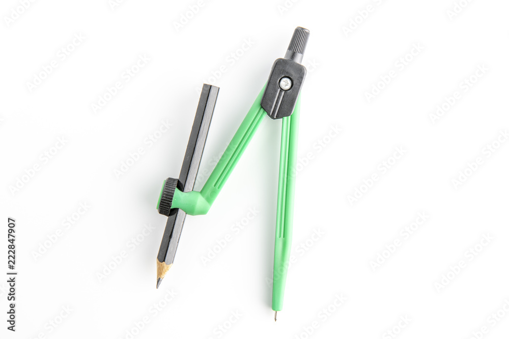 Green plastic compass with pencil and protractor on a white background