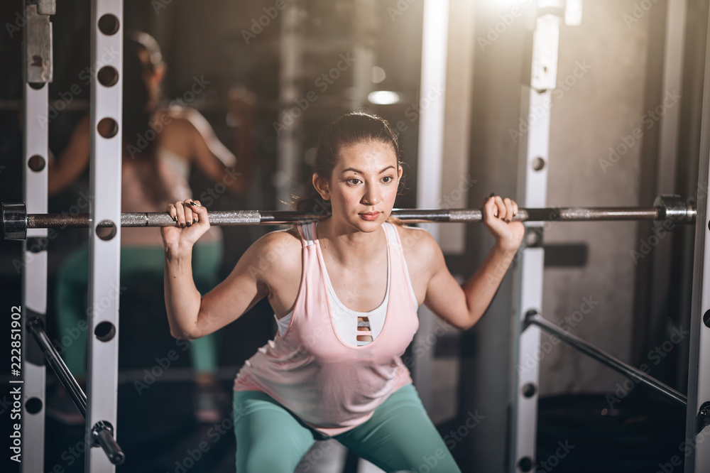 Attractive fit woman in fitness gym,her play Weight-lifting acting strong, builder muscles concept successful Attractive fit woman in fitness gym,her play Weight-lifting acting strong, builder muscles concept successful