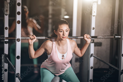 Attractive fit woman in fitness gym,her play Weight-lifting acting strong, builder muscles concept successful
