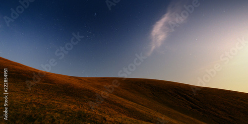 Night panoramic landscape in the mountains. Rolling hills, starring sky. Panoramic view. Svydovets, Ukraine.