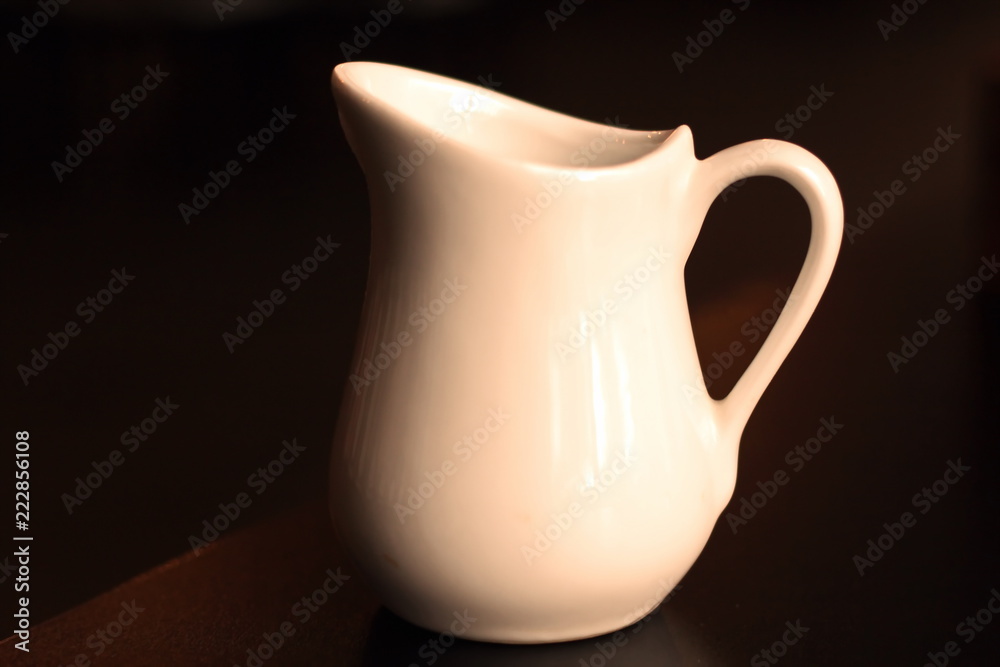 A close-up view of the top and side cups of coffee and a saucer and a jug  with milk. Stock Photo