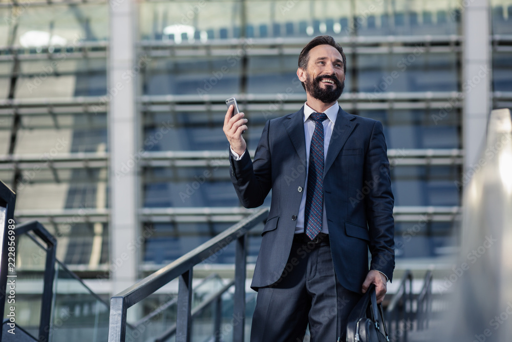 Jouful bearded businessman getting a phone call Jouful bearded businessman getting a phone call