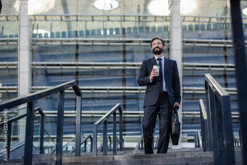 Wallpaper Mural Positive bearded smiling businessman drinking coffee in urban settings Torontodigital.ca