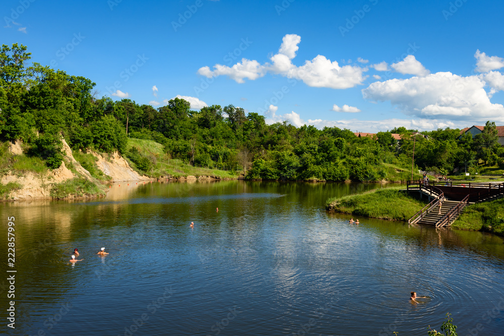 OCNA SIBIULUI, ROMANIA - MAY 28. Salt lake with people swimming and floating in salt water of natural thermal spa lake of Ocna Sibiului on May 28, 2017 in Sibiu, Transylvania, Romania.