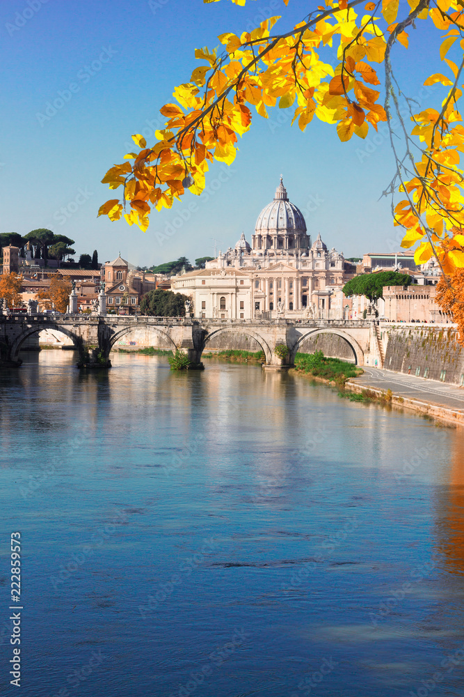 St. Peter's cathedral over bridge and river water in Rome, Italy at fall