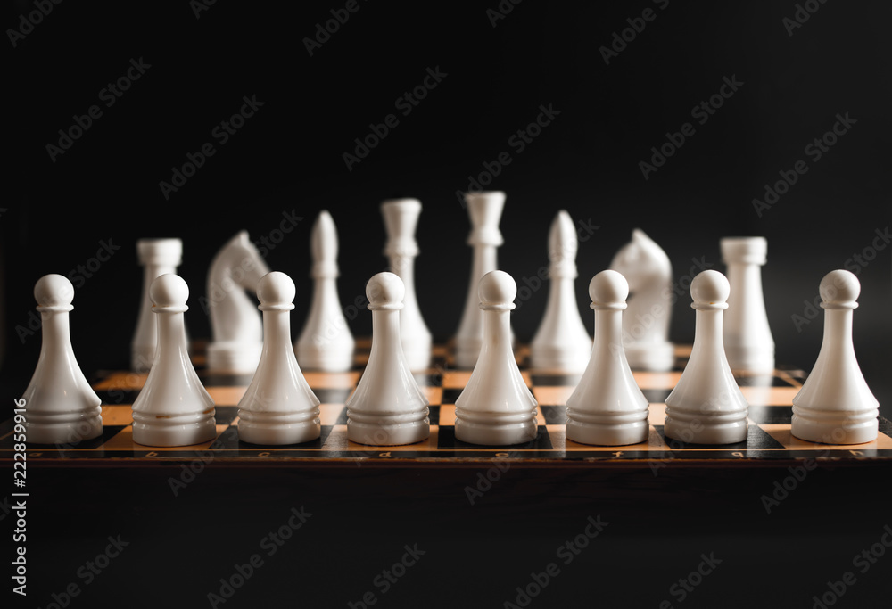 Chess pieces in a row, black background Chess pieces in a row, black background