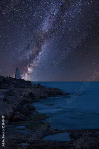 Vibrant Milky Way composite image over landscape of Rocky cliff landscape over ocean