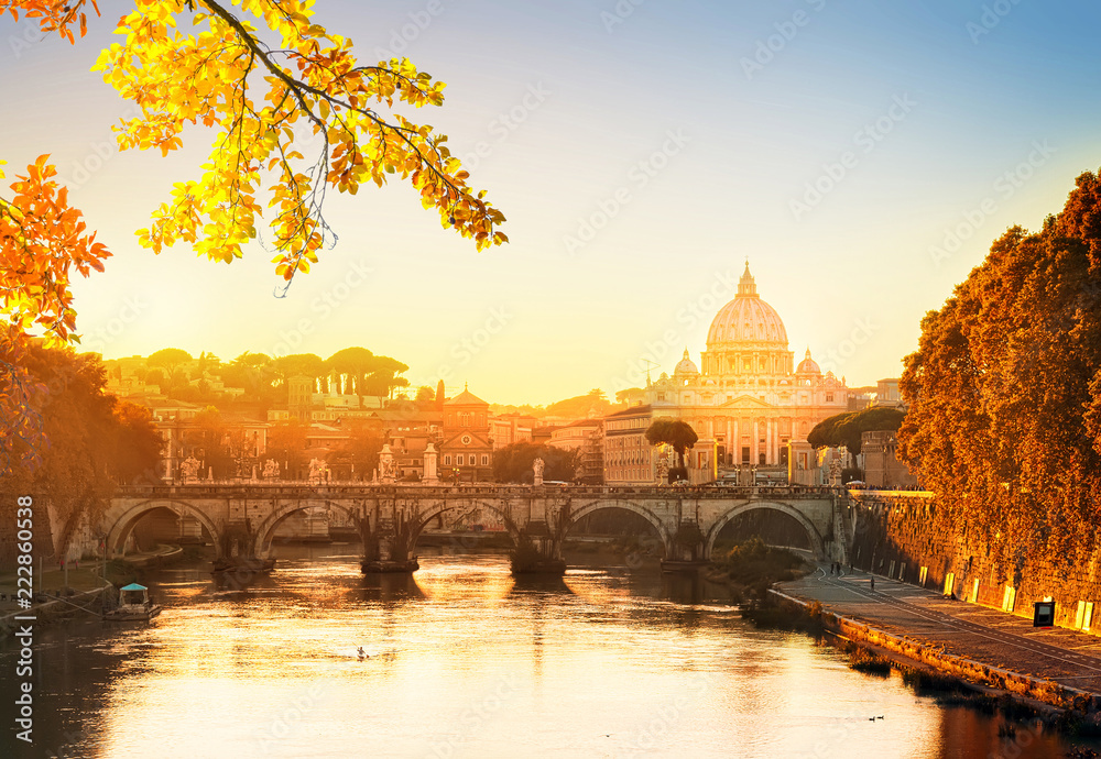 St. Peter's cathedral over bridge and river in Rome at sunset, Italy at fall