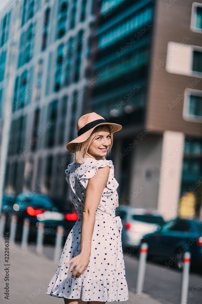 Portrait Beautiful young blonde girl in modern hat with full lips  posing and smiling on  the street lifestyle  on sunny day 