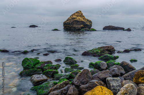 The photo of the stone on the beach on the long exposure