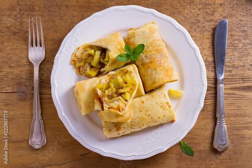 Apple cinnamon crepes. Pancakes with caramelized apples and cinnamon. View from above, top studio shot