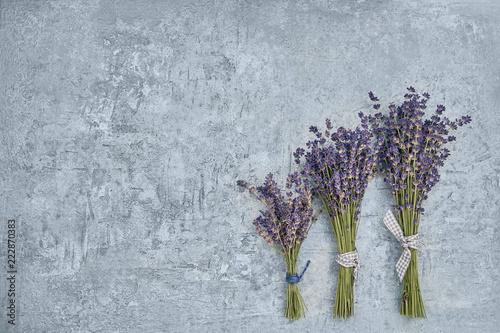 Fototapeta Naklejka Na Ścianę i Meble -  Three bouquet of lavender flowers on gray background. Copy space, top view.
