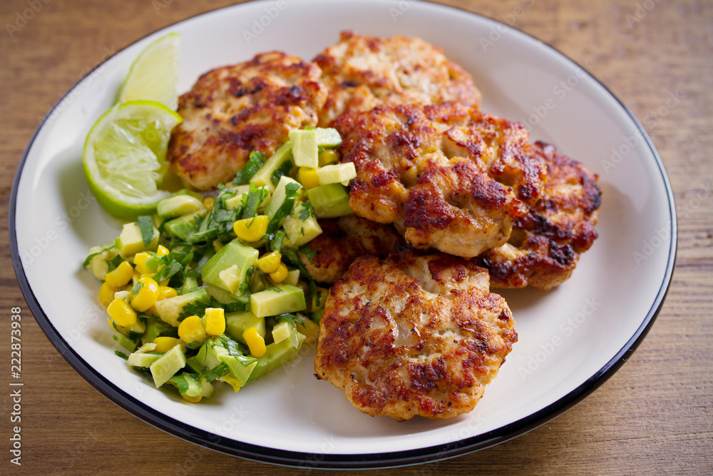 Homemade chicken patties or burgers with avocado corn salsa. horizontal Homemade chicken patties or burgers with avocado corn salsa. horizontal