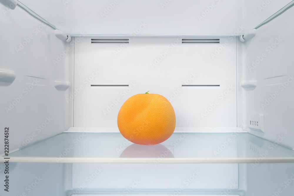 Bright orange grapefruit into fridge
