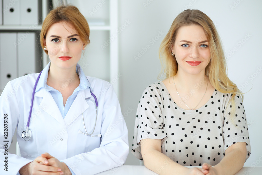 Doctor and patient discussing something while sitting at the desk at hospital. Medicine and health care concept Doctor and patient discussing something while sitting at the desk at hospital. Medicine and health care concept