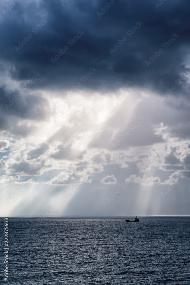 The sun's rays over the sea in the cloudy sky