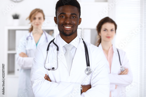Happy african american male doctor  with medical staff at the hospital. Medicine concept