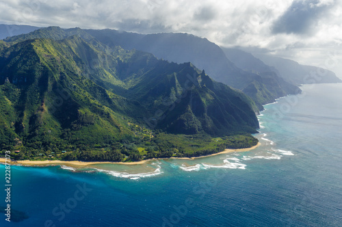 View on the mountains of Kauai's north coast with Kee Beach and the reef from Kailio Point. Na Pali Coast is in the background. Aerial shot from a helicopter, Kauai, Hawaii.