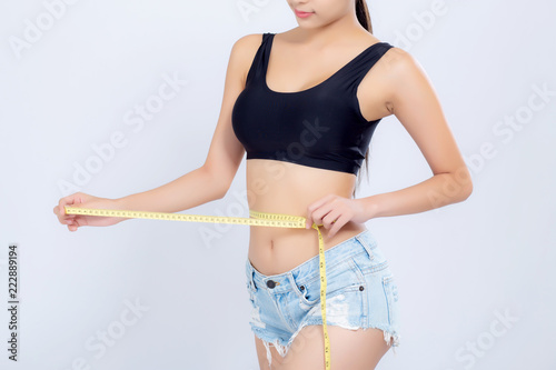 Closeup asian woman diet and slim with measuring waist for weight isolated on white background, girl have cellulite and calories loss with tape measure, health and wellness concept.