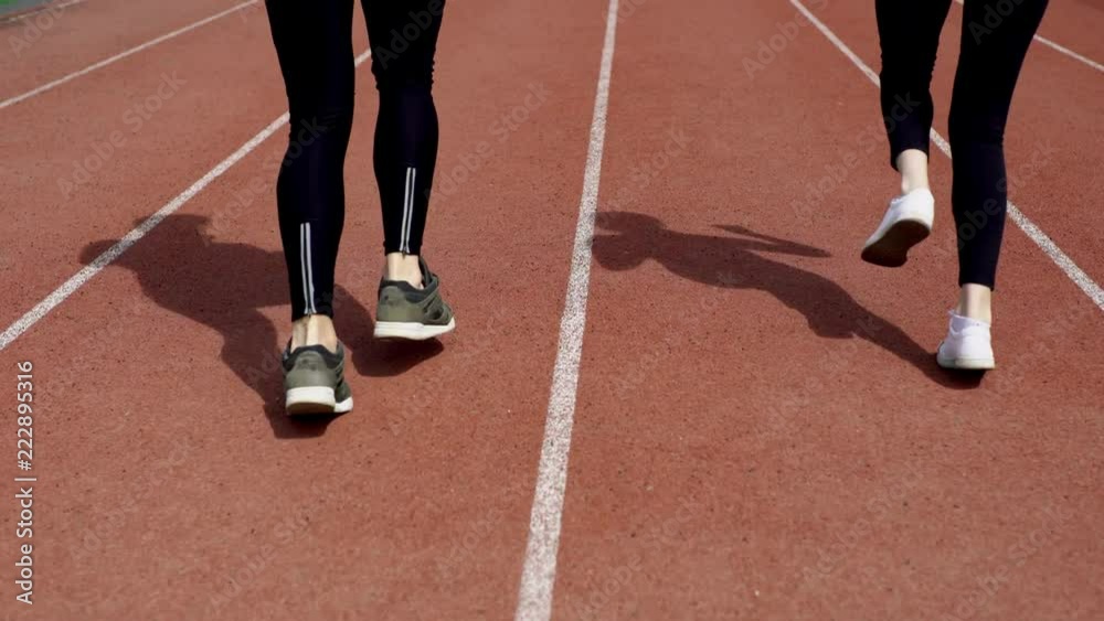 Women are jogging together on a stadium racetrack Women are jogging together on a stadium racetrack