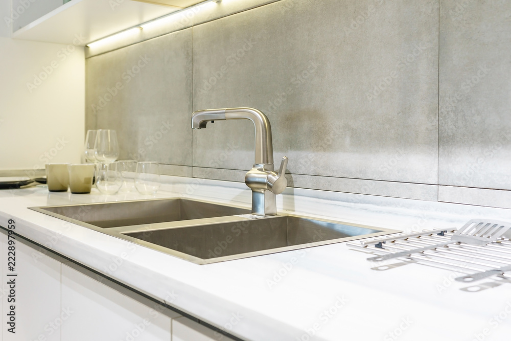Stainless kitchen sink and Tap water in the kitchen. The interior of the kitchen room of the apartment. Built-In Appliances. Kitchen Appliance. Domestic Appliances Stainless kitchen sink and Tap water in the kitchen. The interior of the kitchen room of the apartment. Built-In Appliances. Kitchen Appliance. Domestic Appliances