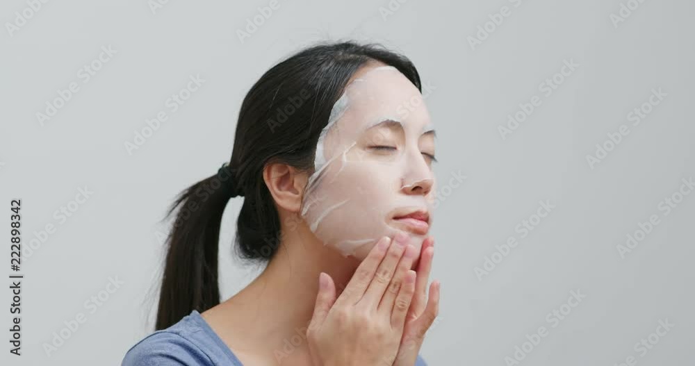 Woman apply paper mask on face Woman apply paper mask on face