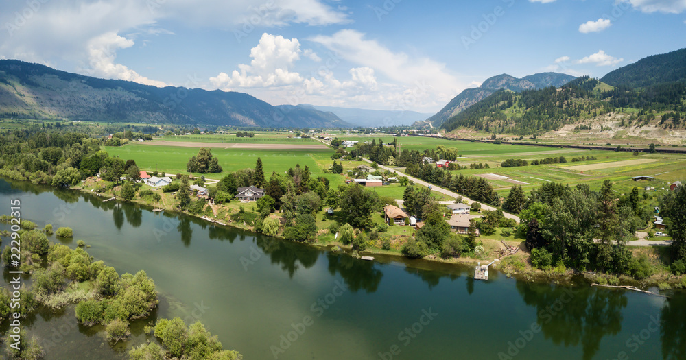 Aerial panoramic view of the Farm fields by Thompson River during a vibrant sunny summer day. Taken near Chase, BC, Canada.