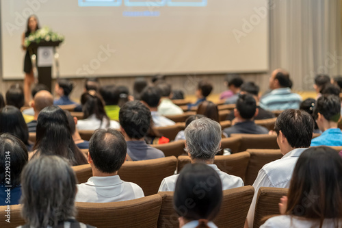 Back side of audience listening the Speaker with podium on the stage in the conference hall, business and education concept