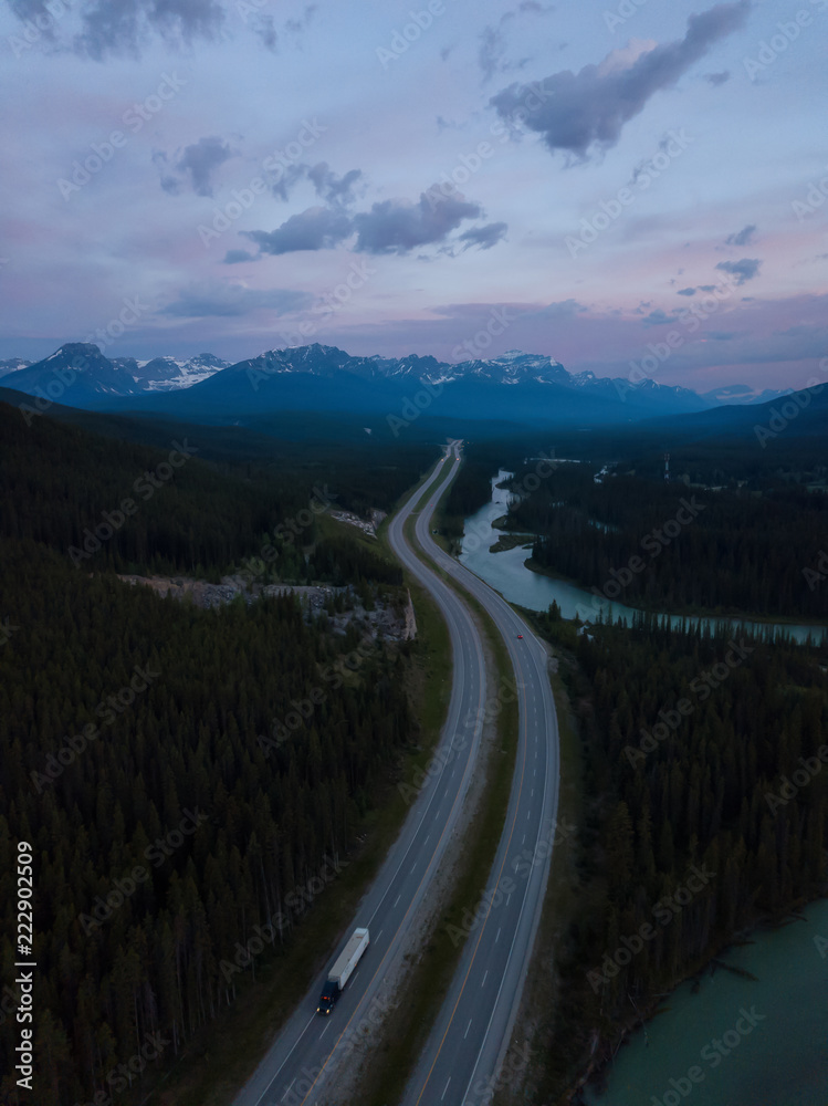 Beautiful aerial landscape view of a Trans-Canada Highway in Canadian Rockies during a vibrant sunny day. Taken in Banff, Alberta, Canada.