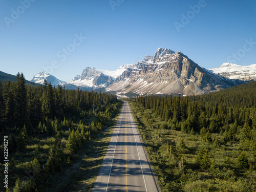 Fototapeta Naklejka Na Ścianę i Meble -  Aerial view of a scenic road in the Canadian Rockies during a vibrant sunny summer day. Taken in Icefields Parkway, Banff, Alberta, Canada.