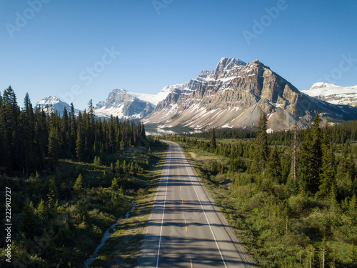 Aerial view of a scenic road in the Canadian Rockies during a vibrant sunny summer day. Taken in Icefields Parkway, Banff, Alberta, Canada.
